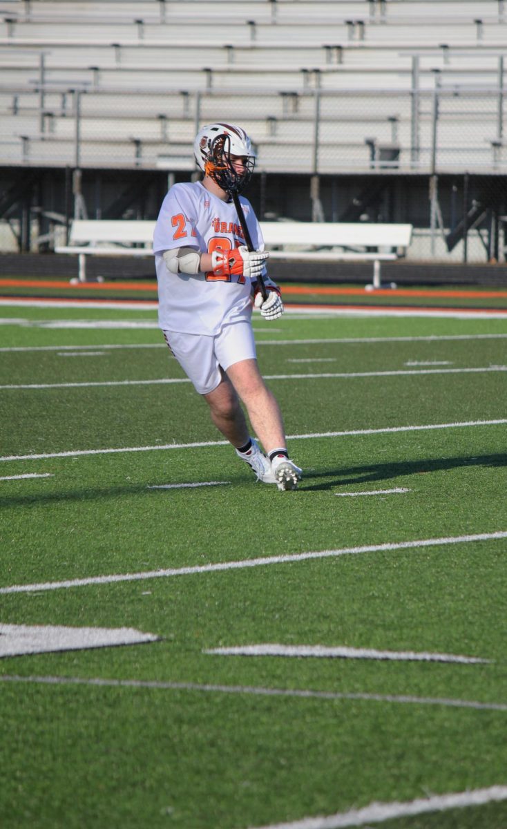 Attempting to catch the ball, sophomore Aiden McKenna communicates with his teammates. On Apr. 11, the boys lacrosse team played brandon and won 10-2. 