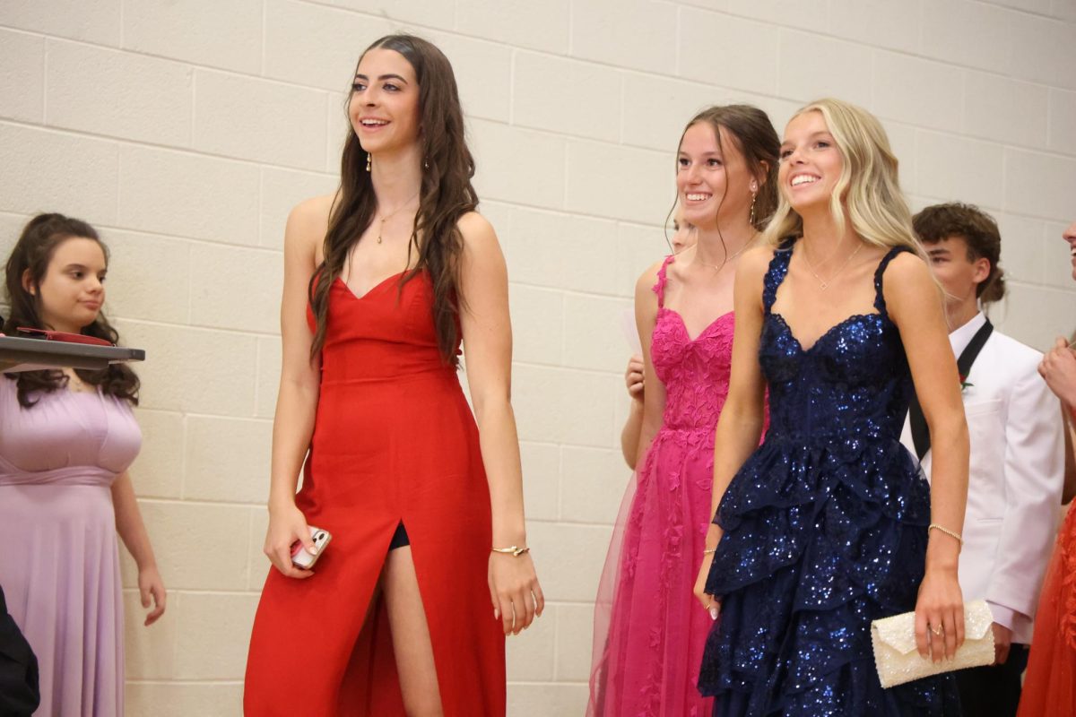Smiling, juniors Karley Russell, Kallyn Sprague, and Emily Kaplan wait in line for their turn to walk. On May 16, FHS held a red carpet bridge for prom. 