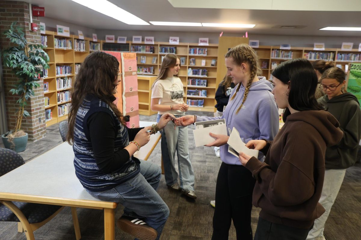Buying, freshman Ava Holmes participates in the spanish market. on May 19, spanish 2 and 3 held a market.