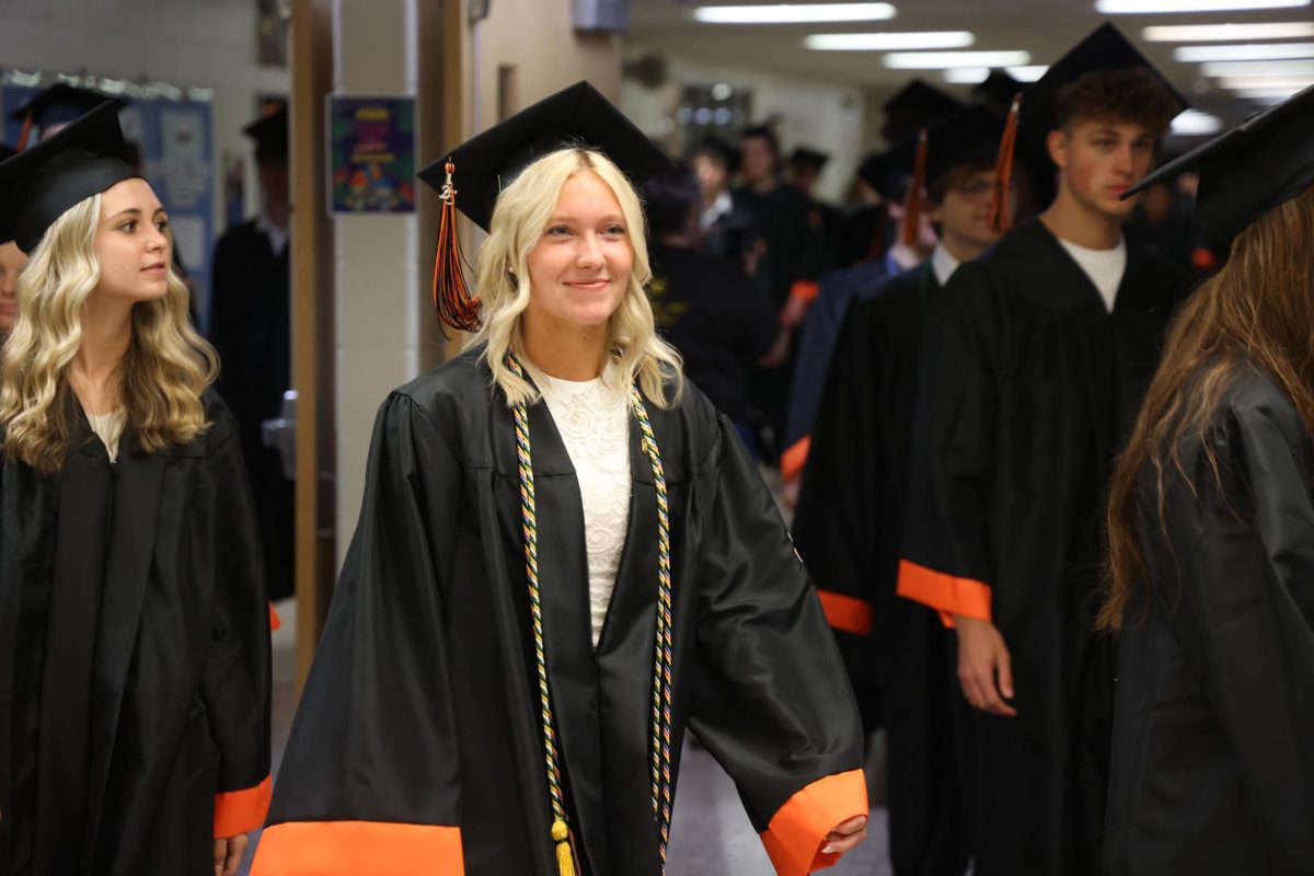 Smiling, senior Madaline Knight walks through the school on the way to the honors assembly. On  May 21, the high school held a clap out for seniors.