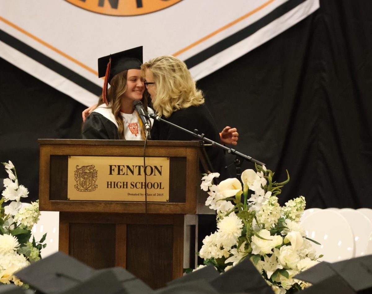 Hugging, Senior Hannah Lee smiles as superintendent Ciesielski gives her an award. On May 21, Fenton High held an award ceremony for graduating seniors.