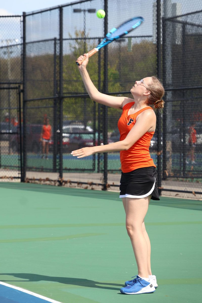 Swinging, senior Emma Rush looks at the ball. On May 8, the FHS girls varsity tennis team played against Holly High. 