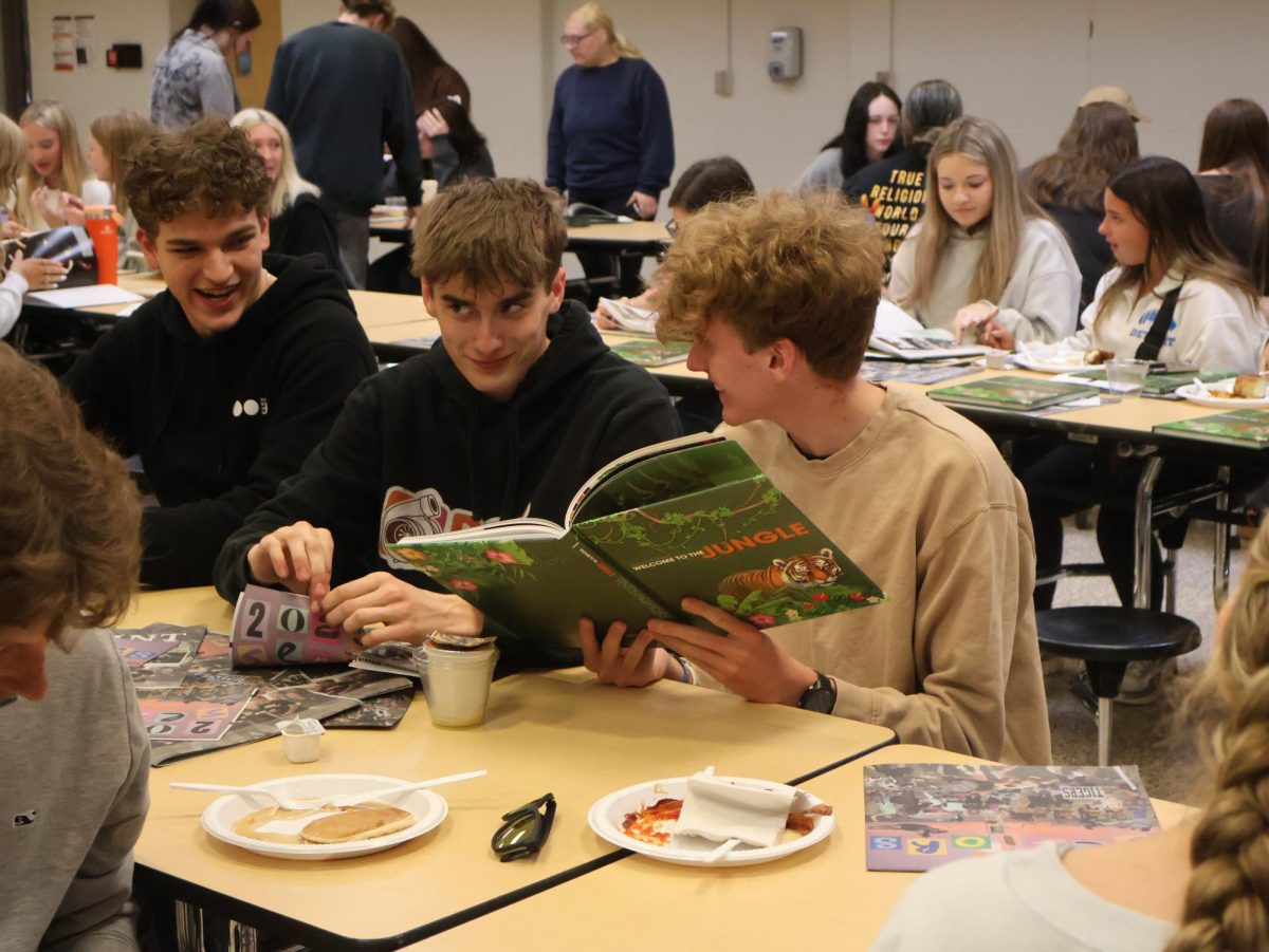 Looking, senior Ethan Brzezinski sits at a table with his friends. On May 20, graduating seniors attended a breakfast celebration.