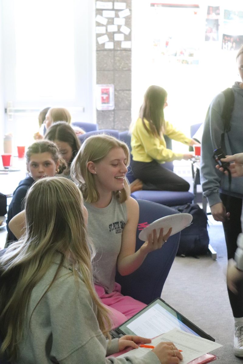 Smiling, junior Ava Watson receives her paper plate award. On May 8, the Fenton Yearbook Staff held a party during fourth hour.