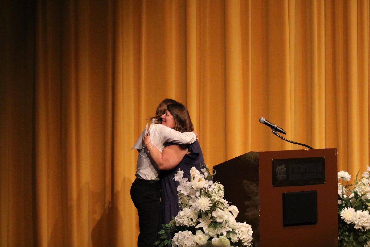Hugging, senior Madison Sheffield receives a scholarship at senior night. On May 13, Fenton High held scholarship night for graduating seniors.