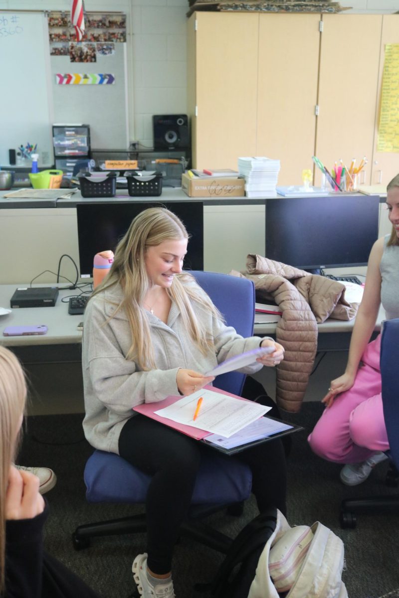 Smiling, junior Evie Metcalfe receives her paper plate award. On May 8, the Fentonian staff celebrated the end of the year by creating paper plate awards for each other.  