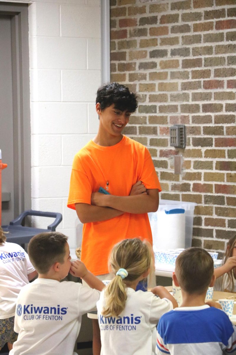 Speaking, junior Kavuan Gregory talks with the children. On Aug. 6,  Safety Town was hosted at Fenton High during the summer.