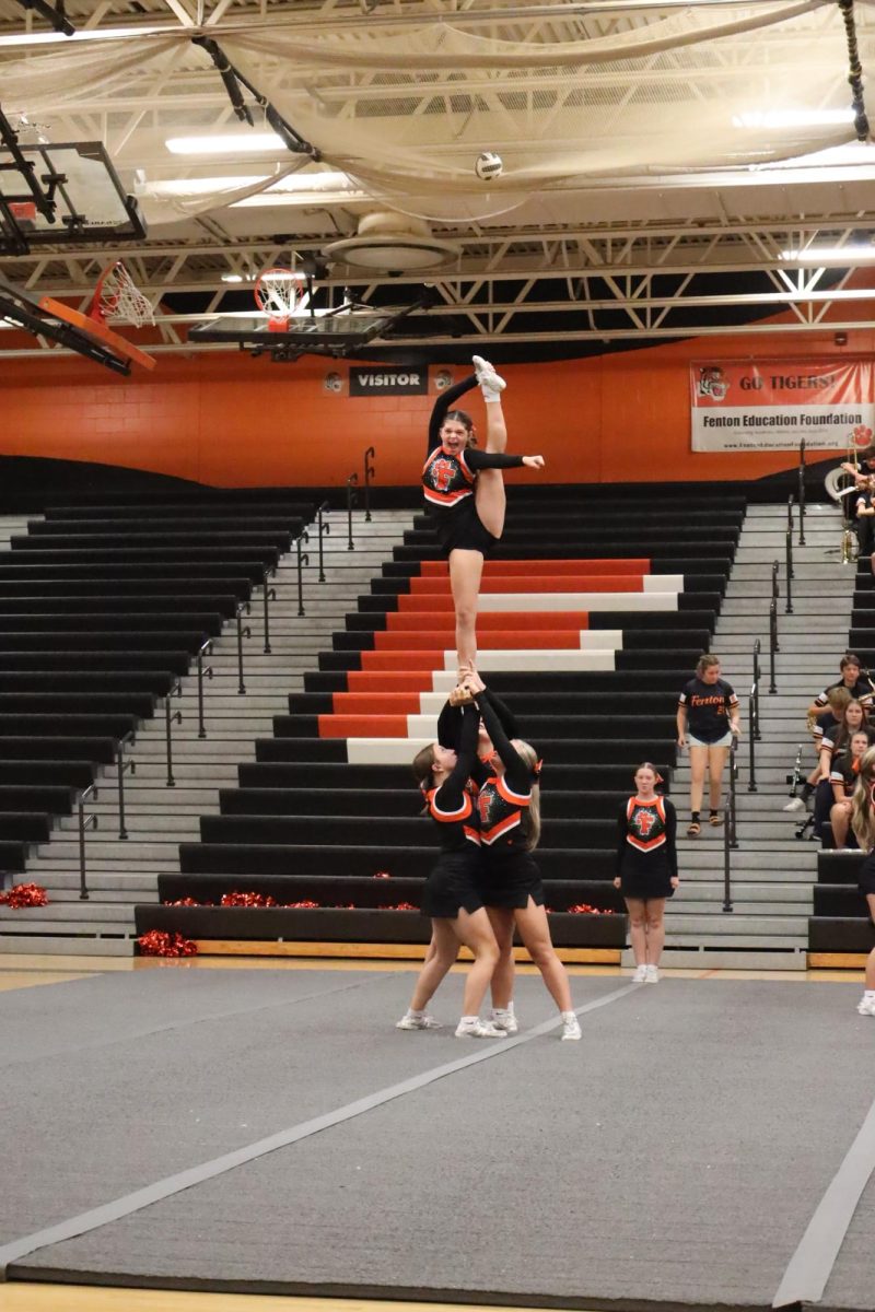 Stunting to the crowd, junior Kenna Bigger does a “bow.” On Sept.19, Fenton High held a pep rally for their homecoming.
