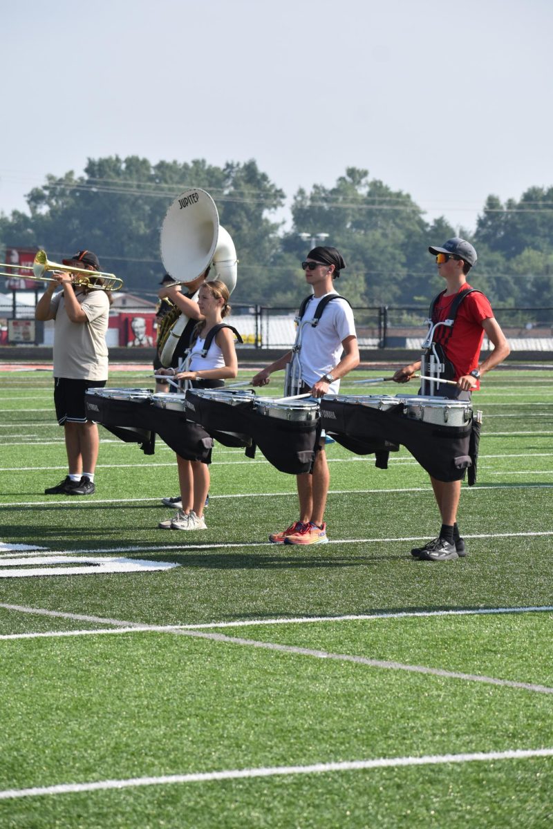 Standing, senior Peyton Thorp, Joe Wright and junior Klayton Yoerg stay in set position. On Aug. 14, the Fenton Marching Tigers held a practice at the football field.