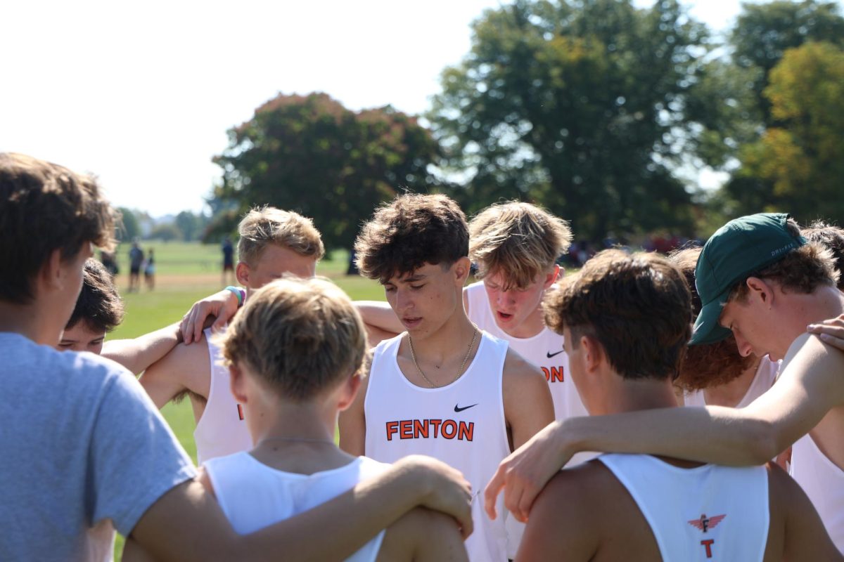 Thinking, junior Jackson Defina is doing the tiger prayer for the cross country team. The cross country team does this before every race.