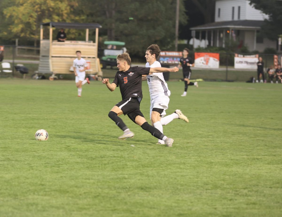 Sprinting down the field, junior Grant Geiersbach runs after the ball. On Sept. 22, the Fenton varsity soccer team played Linden and won 8-0.
