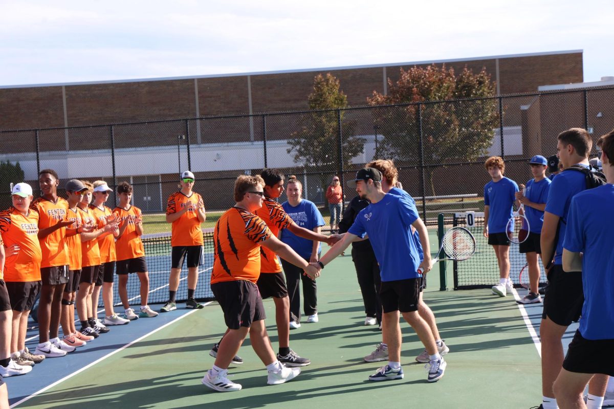 Shaking hands, sophomore Parker Smelis is getting ready for his tennis match against Brandon High School. On Sept. 23, the Tigers played against the Blackhawks.