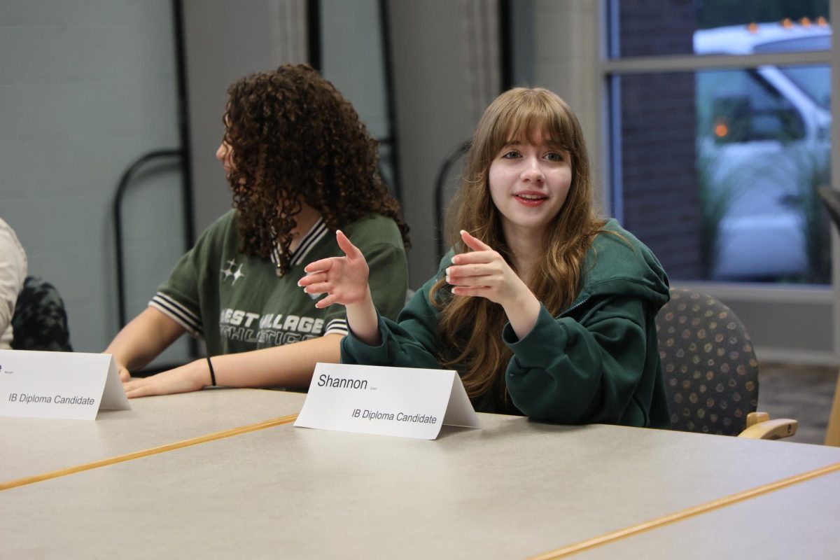 Talking with others, junior Shannon Golen and other International Baccalaureate students participate at the IB program evaluation meeting. On Sept. 25 Shannon is answered a question asked by the evaluators. 