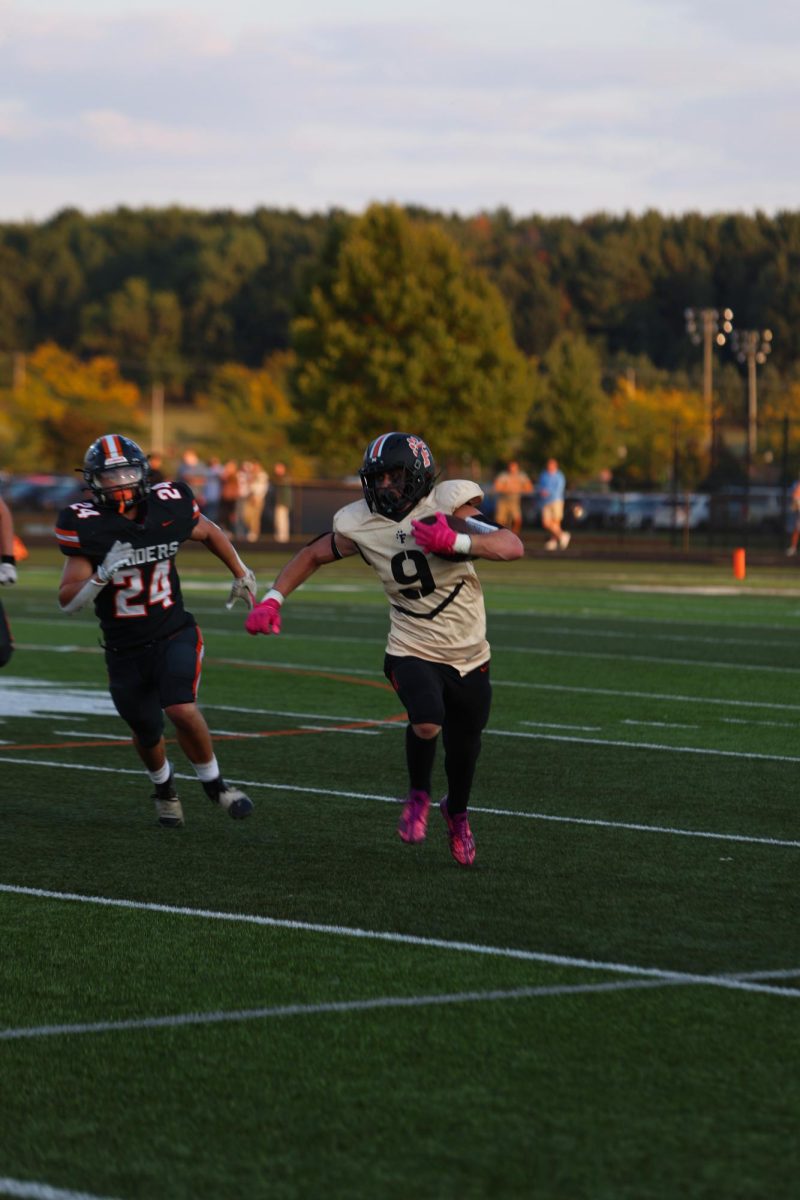 Running, senior Trenton Boucha gets past the defenders. On Sept. 12, the Fenton varsity football team went against Flushing and won. 