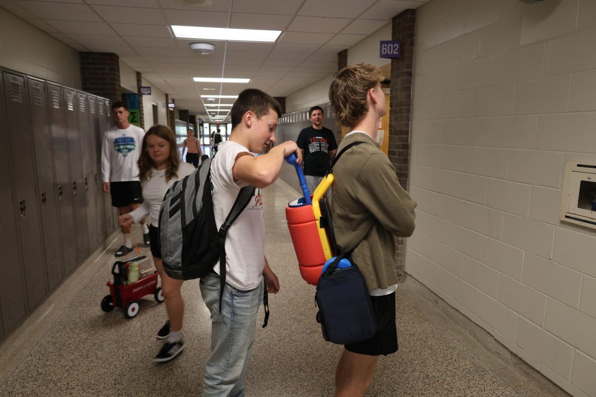 Stuffing his backpack junior Maverick Salerno helps junior Ben Marks pack his stuff. On Sept. 17 Salerno and Marx participate in "anything but a backpack day" at Fenton High, to show Homecoming pride.