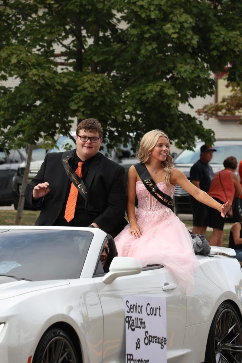 Smiling, seniors Hunter Sayer and Kallyn Sprague wave at the crowd. On Sept. 19, downtown Fenton held a parade for Homecoming. 