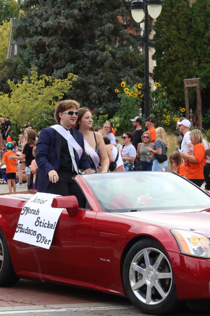Smiling, junior Hudson Dyer and Norah Stickel ride in a car for homecoming court. On Sept. 19, Fenton held their annual Homecoming parade.