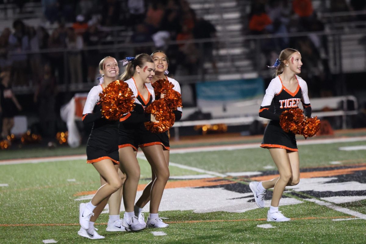 Smiling, sophomores Ella Price, Aria Guru and Erin Walrath are running up to the field to get ready for halftime. On Sept. 12, Fenton went up against Flushing, winning 41 to 12.