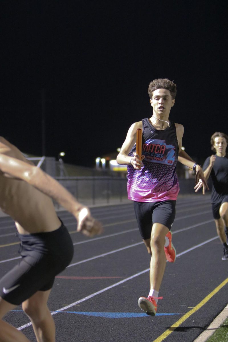 Running, junior Jackson Definia races in a meet. On Sept. 18, the Fenton Cross Country team held a night to sleep on the football field and participate in team-bonding activities.