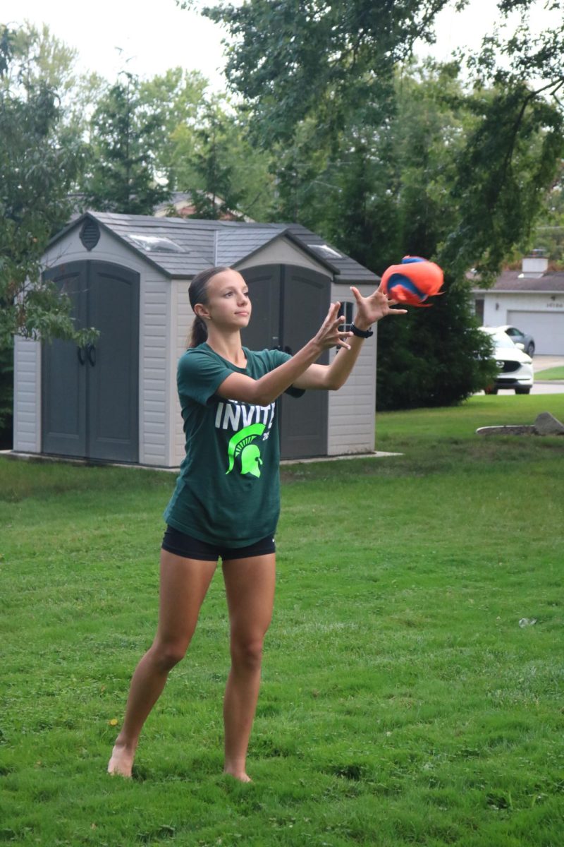 Receiving, sophomore Lucy Bott catches the ball at Pasta Party. On Sept. 23, the Fenton Cross Country team held a Pasta Party to prepare for a meet the next day.