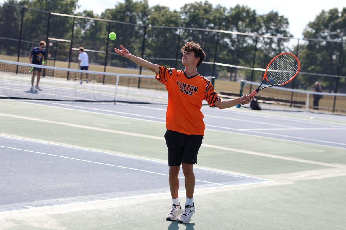 Watching the ball, junior Kavaun Gregory gets ready to serve. On Sept. 11, the boy's tennis team played Owosso and lost.