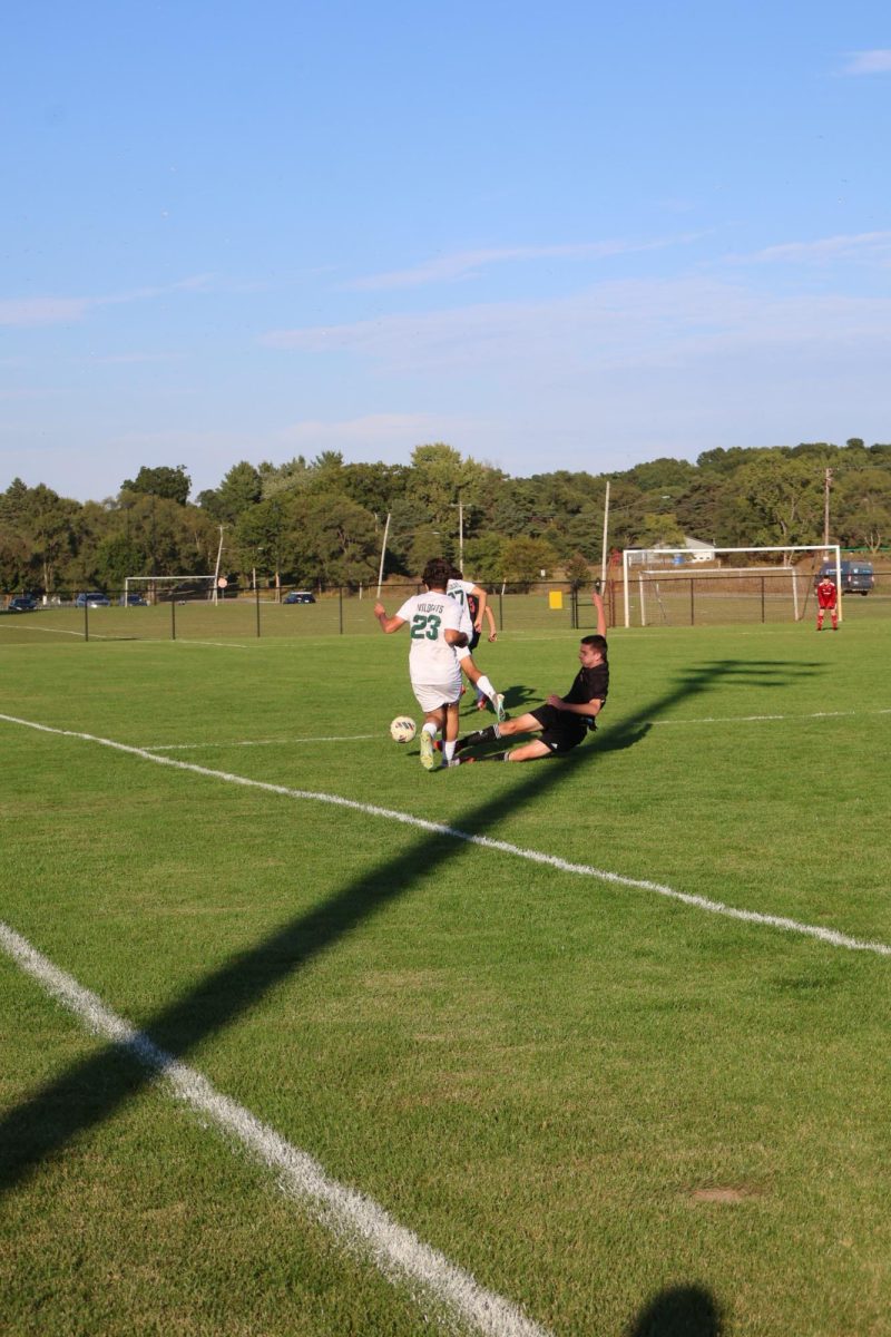 Sliding, freshman Ben Koscielniak kicking the ball. On sept. 10 at the JV soccer game vs. Corunna. Fenton won 4-0.
