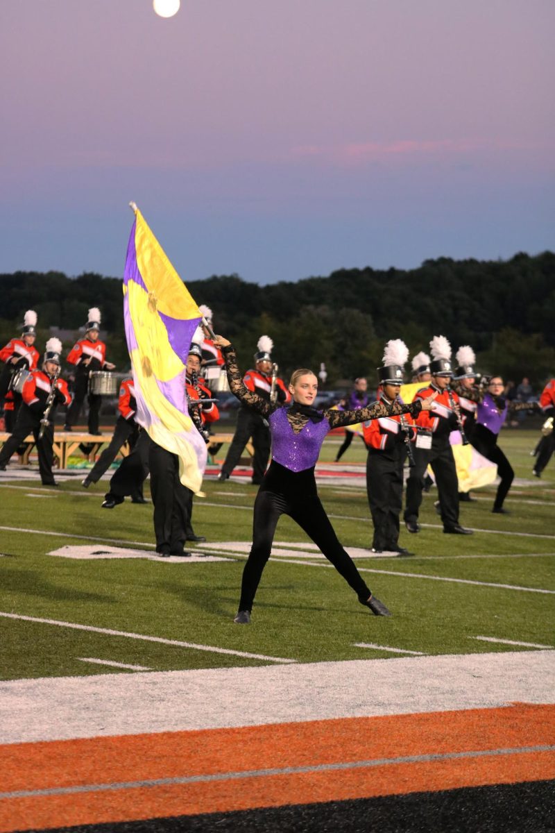 Spinning the flag, sophomore Ava Holmes performs. On Sept. 5, the FHS marching tigers put on their halftime show.