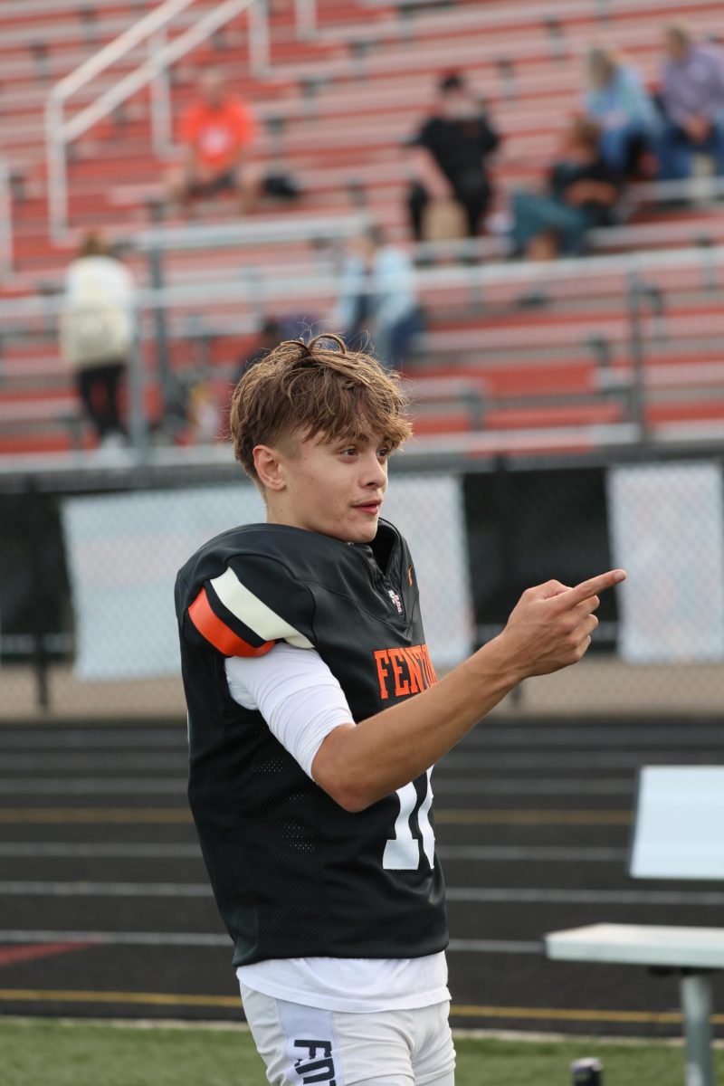 Pointing at the scoreboard, sophomore Alec Mock is happy there winning the game. On Oct. 2, jv football beat Kearsley.