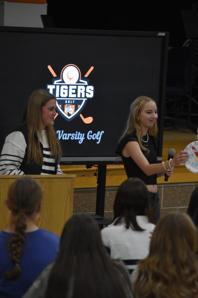 Handing an award, senior Cassie Harris attends the Golf Banquet. On Oct. 21, the varsity girls golf team held a award night.