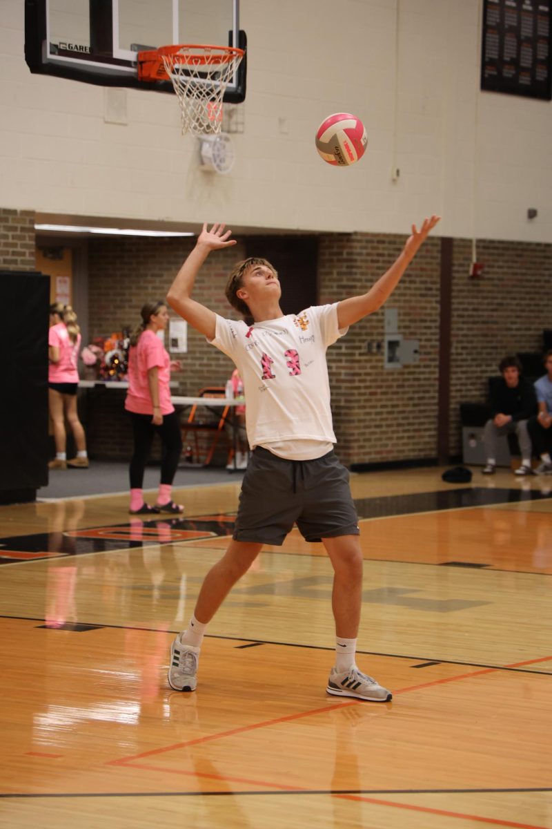 Serving the ball, senior Dane Mckee gets ready to hit over the net. On Oct. 2, FHS had a Volley for a Cure game to support cancer, where the varsity soccer and volleyball teams went head to head. 