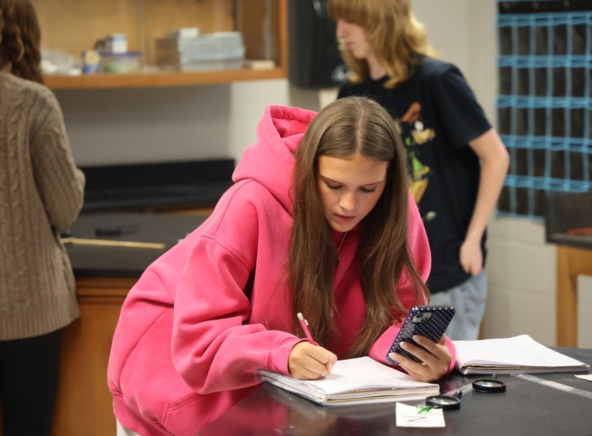 Writing in a notebook, junior Addison Stallings researches data. On Oct. 7, Matt Sullivan’s forensics class completed a lab. 