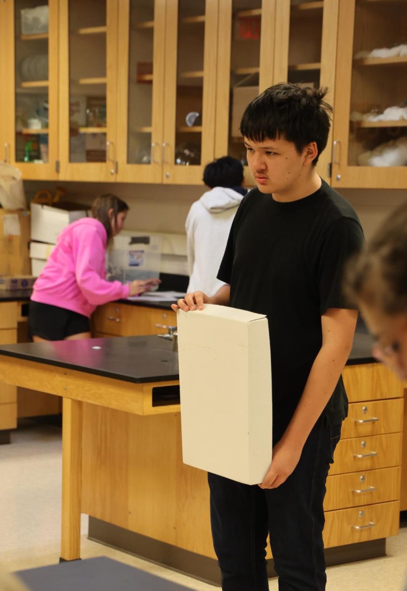 Standing with a box lid, sophomore Lucas Andrews completes a lab. On Sept. 30, Nicholaus Jeffery's physics class completed a lab on motion detection. 
