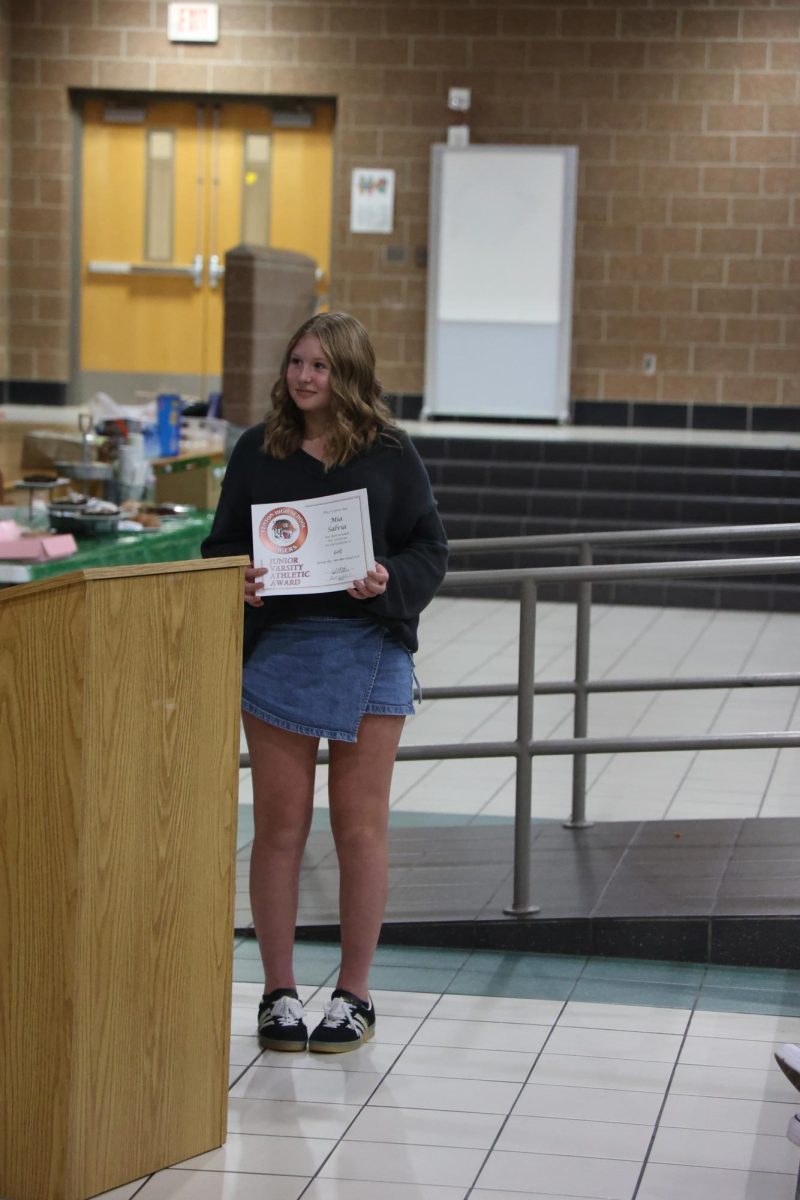 Receiving her award, sophomore Mia Salvia stands in front of her teammates. On Oct. 21 girls' varsity golf team celebrates the end of their fall season with a banquet.