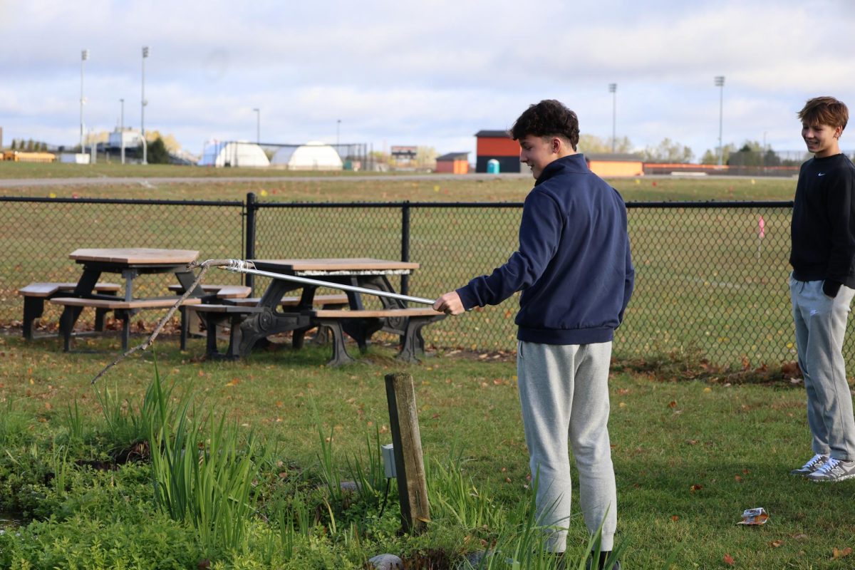 Casting his rod, sophomore Lawson Perry fishes. On Oct. 23, Matt Sullivan's SRT class made fly fishing poles for the pond. 
