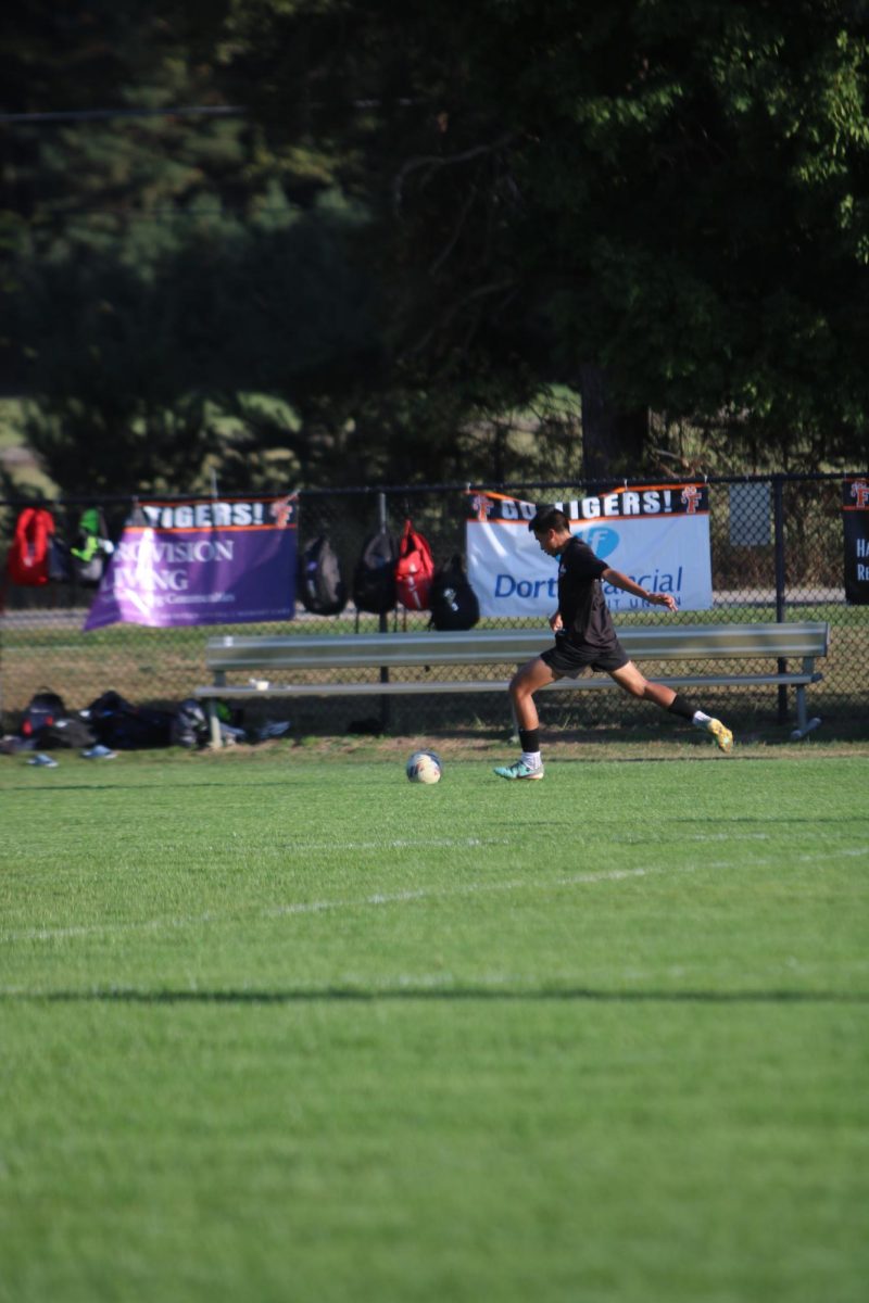 Going to kick the ball, freshman Jake Ayotte attempts to make a goal. On Oct. 6, the Fenton JV Soccer team had a game against Milford and won 1-0.