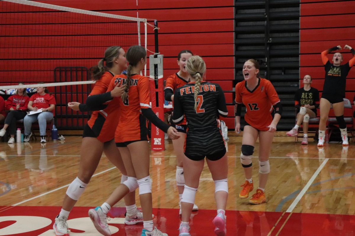 Cheering, Fenton's Jv volleyball team is excited after scoring a point against Holly  High School. On Sept 4, Fenton Jv volleyball won 3-0 


