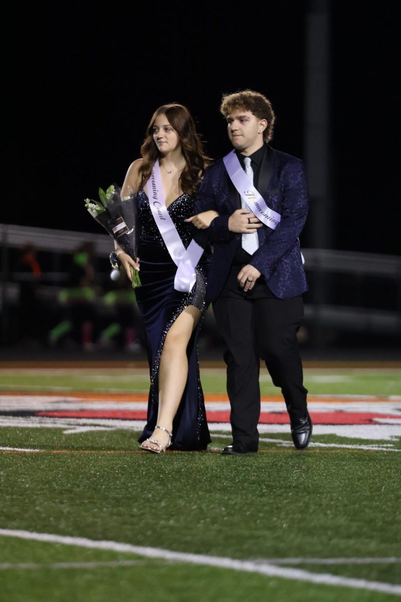 Walking, juniors Norah Stickel and Hudson Dyer represent the Homecoming court. On Sept. 19, FHS held their annual homecoming game. 
