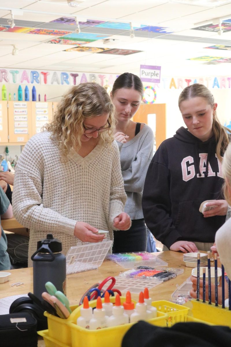 Picking out beads, senior Josie Fries gets beads to make a bracelet. On Oct. 28, Ms. Hamilton and Mrs. Andersen held a Taylor Swift SRT to make friendship bracelets.