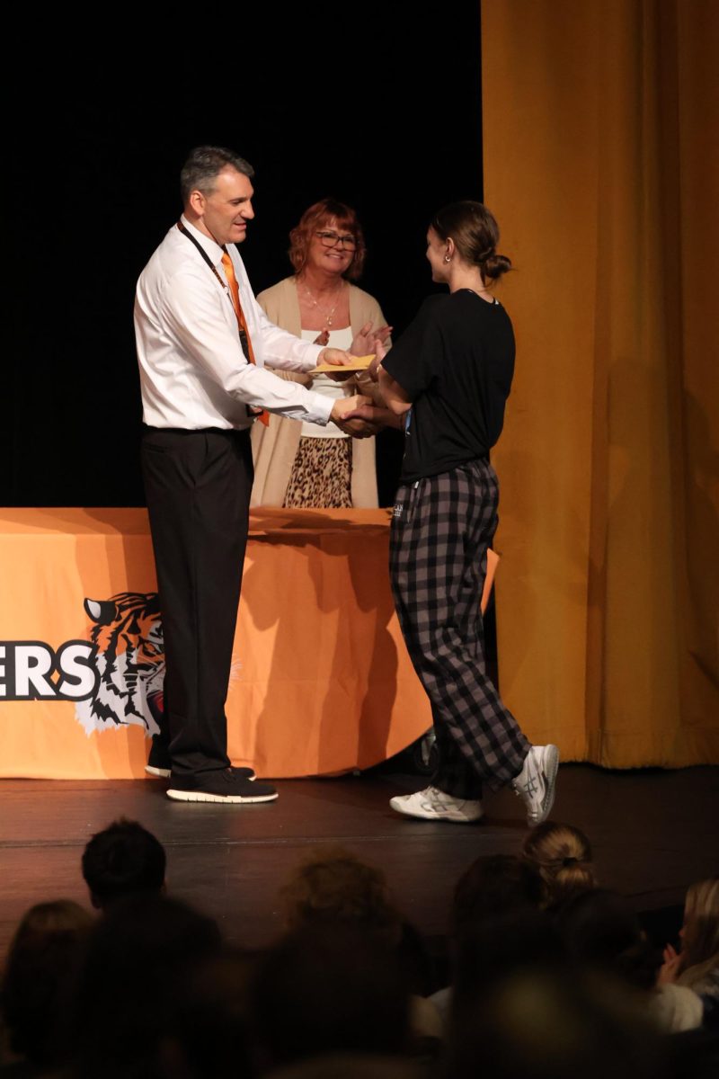 Shaking hands with Principal Michael Bakker, sophomore Grace Wolner receives her academic letter. On Oct. 21, students pick up their academic letters.
