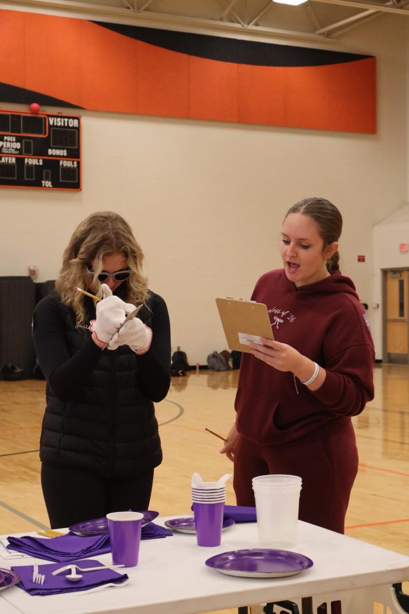 Going through a simulation, seniors Josie Fries and Abigail Golen participate in the Alzheimer's walk. On Nov. 20, the NHS students held an Alzheimer's walk to raise awareness and money.