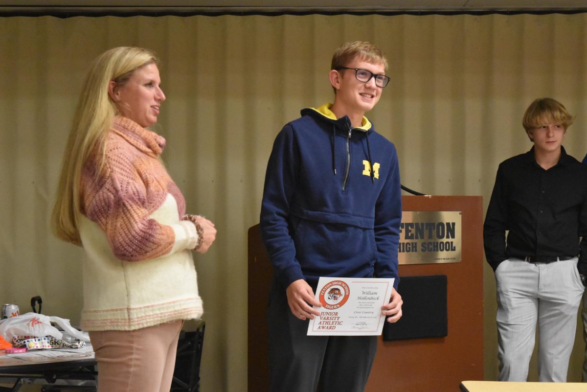 Accepting his award, sophomore William Hollenback receives his JV certificate. On Nov. 12, the boys' cross-country team received its rewards to end the season.