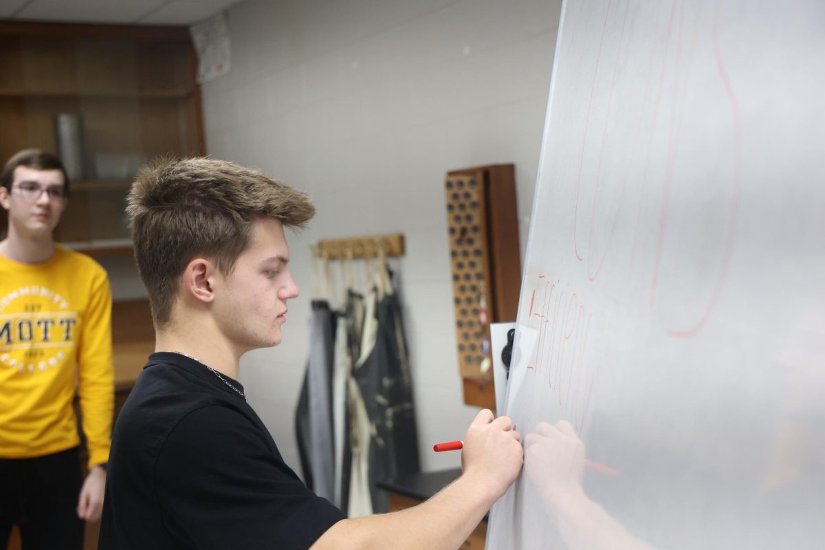 Writing, junior Spencer Phipps is working on his IB project. On Oct. 29, the IB Chemistry and Biology students worked on their project all day.