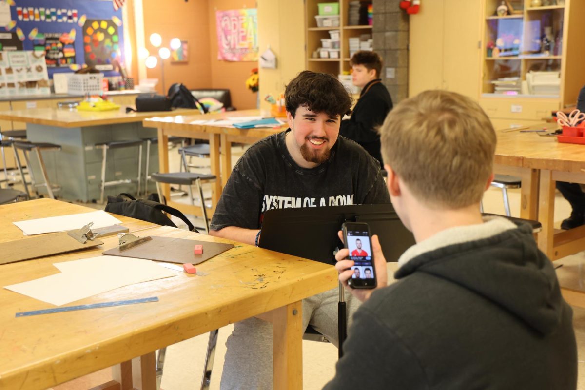 Drawing a portrait, junior Jordan Fisher attends the Forensics SRT. On Nov. 20, science teacher Matt Sullivan’s class visits the art room to learn how to sketch faces.
