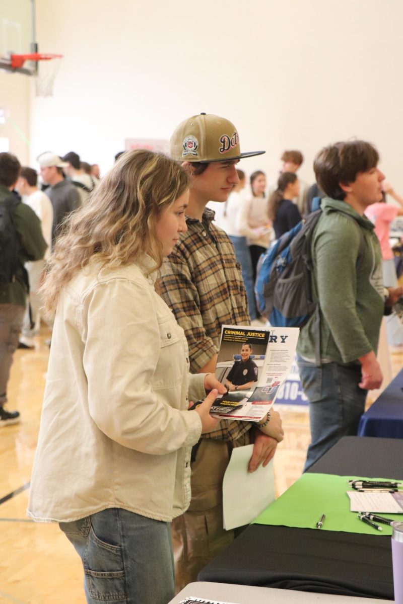  Interested in the topic, junior Brianna Ashley and senior Dominic Maini are looking at one of the college booths. On Nov. 6 FHS held the Career fair for Lake Fenton, Linden and Fenton’s students. 
