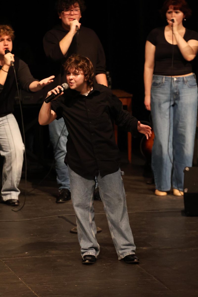 Performing in front of an audience, junior Auggie Zeffero sings "Turn To Stone" by Electric Light Orchestra. On Nov. 15, the FHS ambassadors put on their sneak peek show in the auditorium.