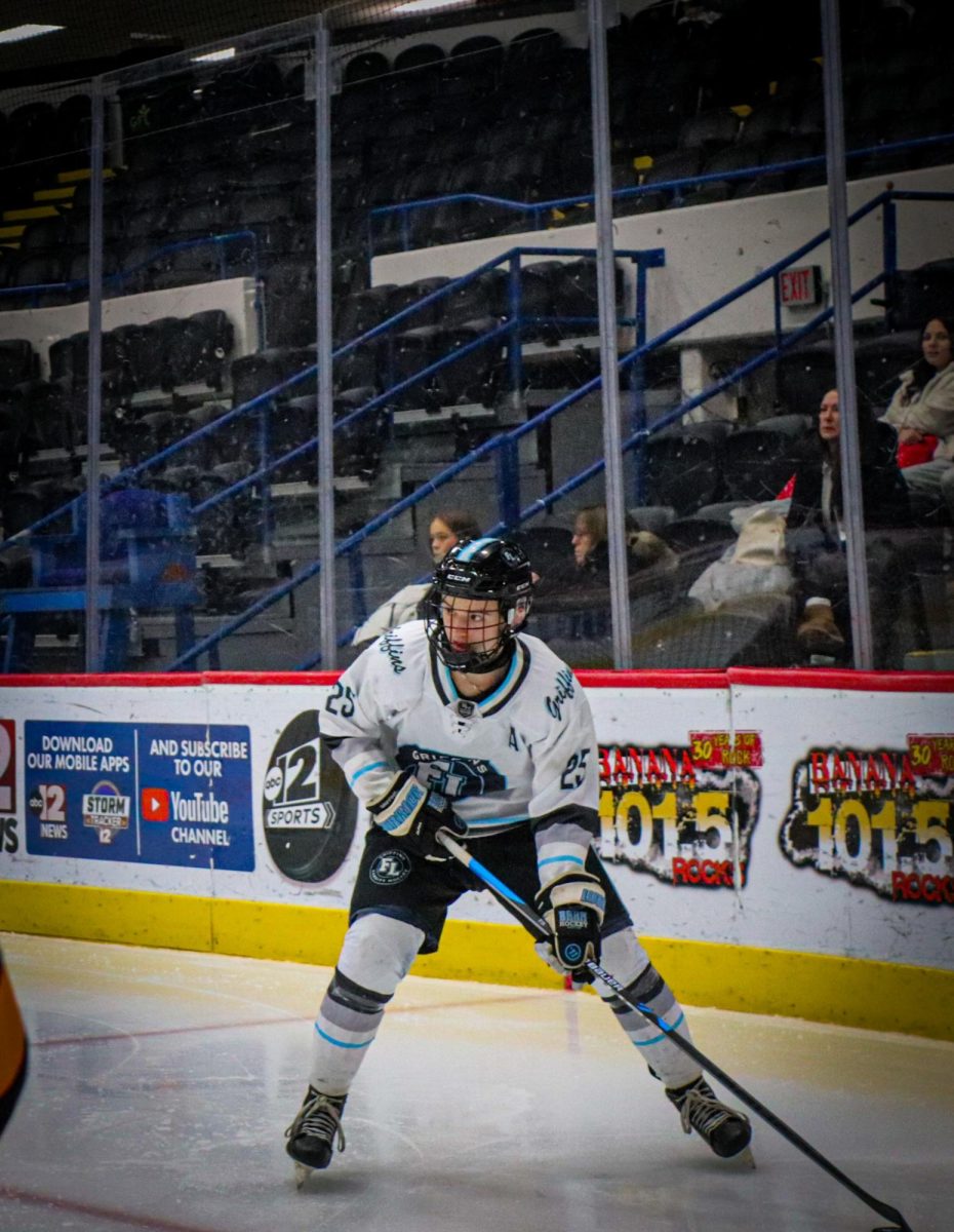 Strategizing how to pass the puck, Senior Mason Write plays in an intense hockey game. On Dec.13, the Griffins hockey team goes up against Granblanc and wins 5-0. 