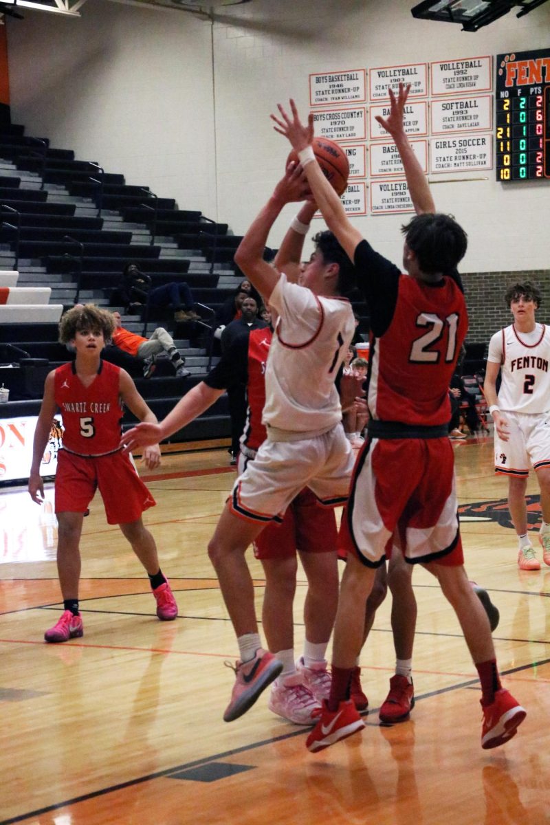 Shooting for the ball, sophomore Brady Pierson goes for the basket. On Dec. 11, the JV boys basketball team went against Swartz Creek and lost. (find score later)
