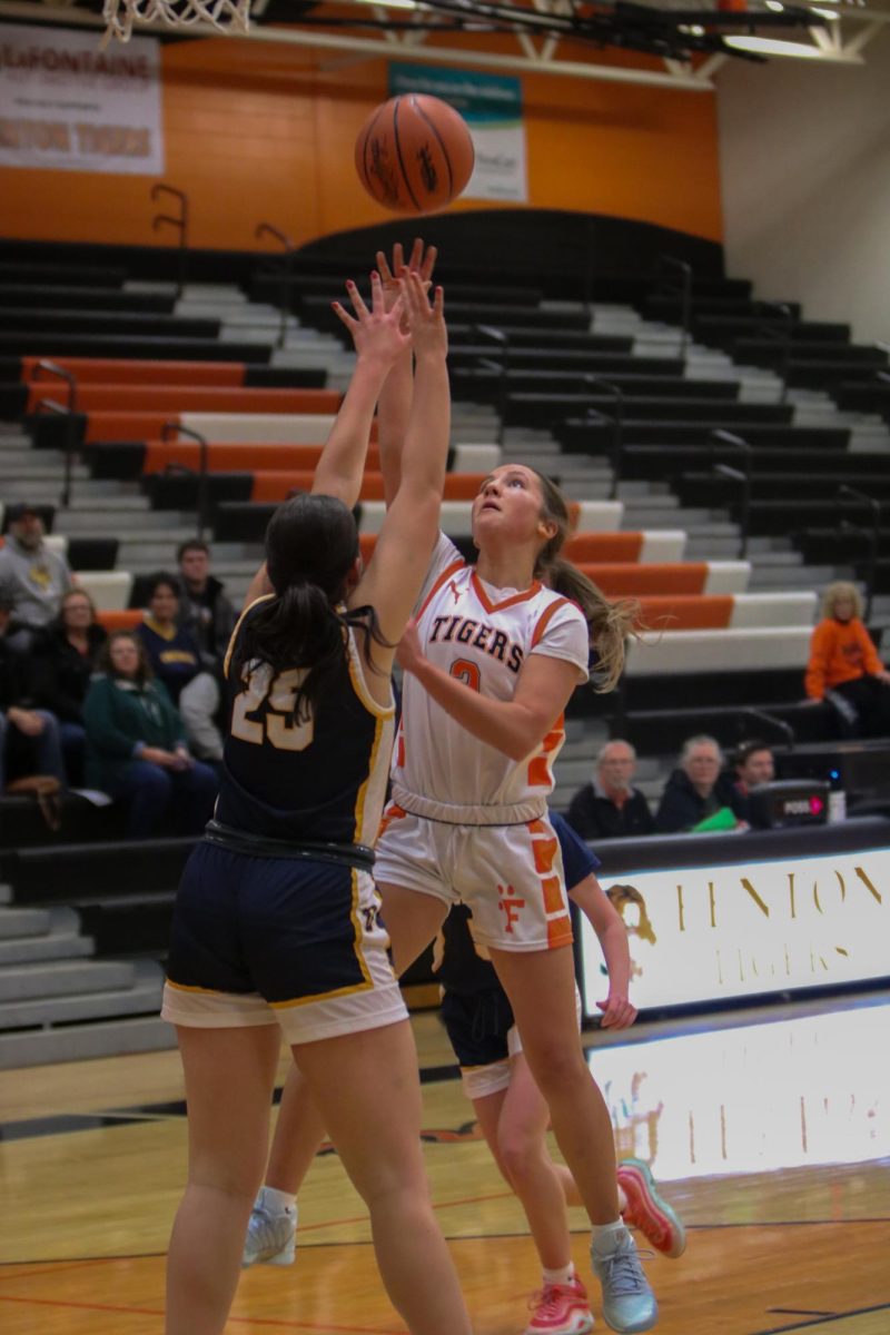 Shooting the ball, junior Maddie Eltringham attempts to make a basket. On Dec. 9, the Fenton Varsity Basketball team had a game against Owosso and won 47-43.