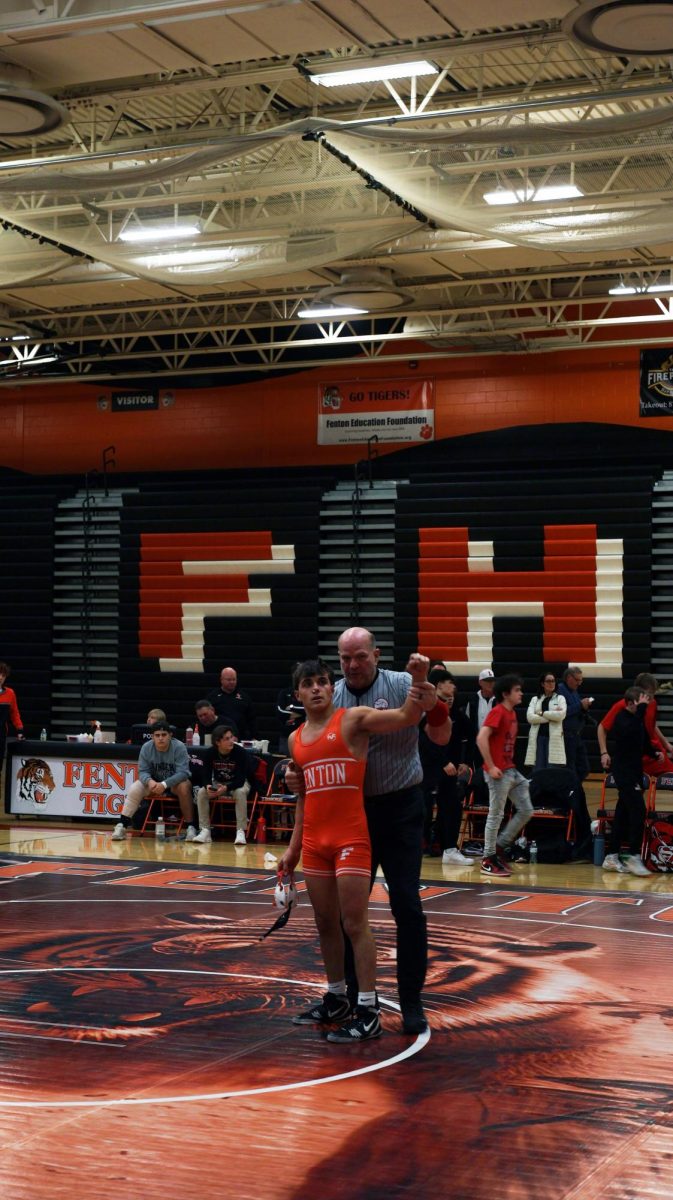 Celebrating his victory, sophomore Logan Christopher beat his opponent from Linden on the mat. On Dec. 17, the boys varsity wrestling team beat Owosso 71-7 but lost to Linden 46-17.