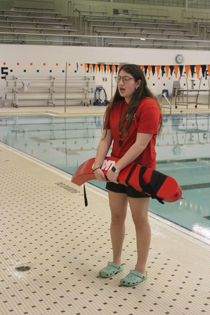 Talking, senior Hayley Jensen explains the pool rules. On Nov. 21, the varsity hockey team held a Hockey Lock-In to raise money. 